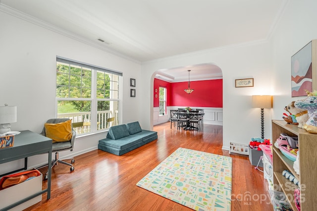 living area featuring hardwood / wood-style flooring and crown molding