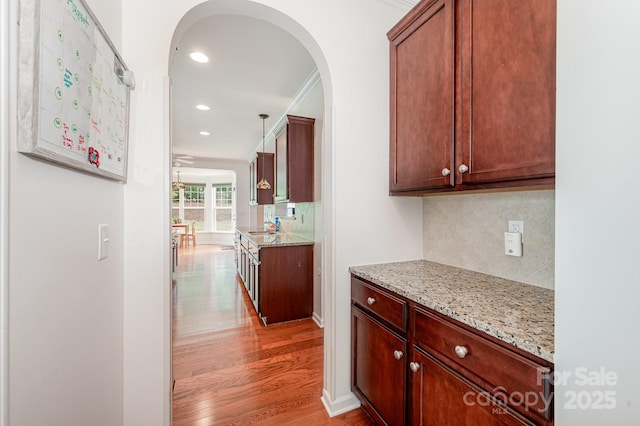 corridor with sink, light hardwood / wood-style flooring, and ornamental molding