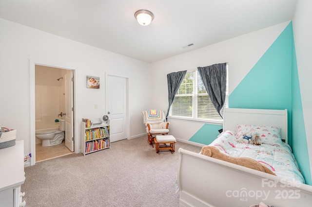 carpeted bedroom featuring ensuite bath