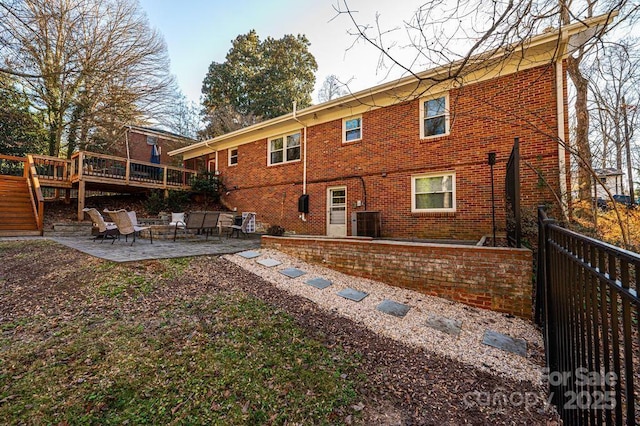 rear view of house featuring a deck, a patio, and central AC