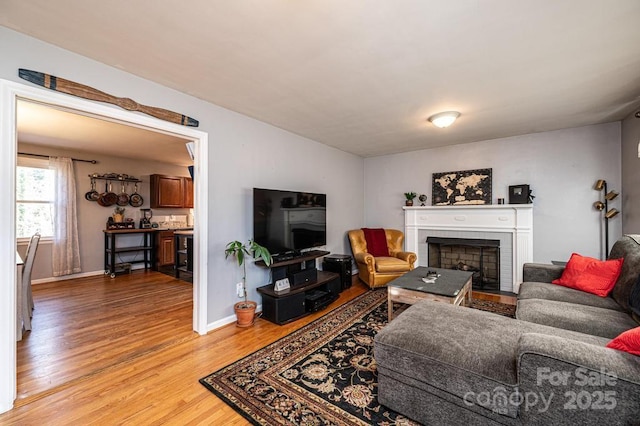 living room featuring hardwood / wood-style flooring and a brick fireplace