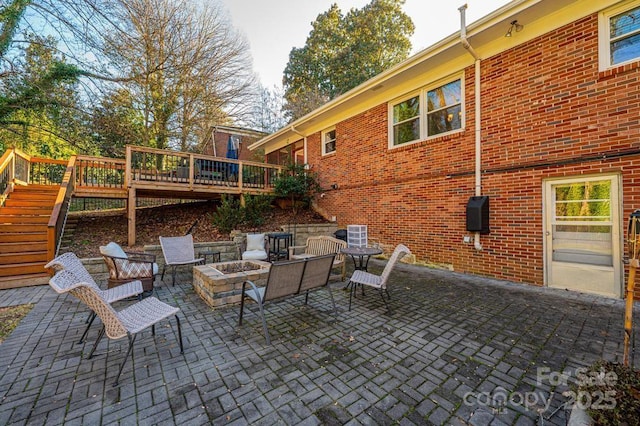 view of patio / terrace with a deck and an outdoor fire pit