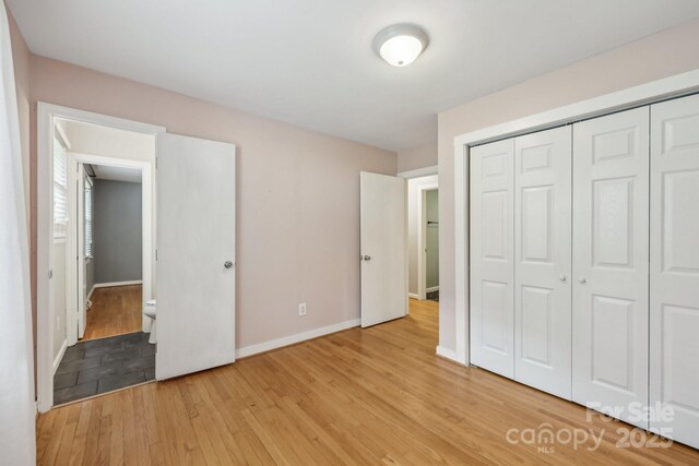 132 30th Ave NW, Hickory, NC 28601 - unfurnished bedroom featuring light wood-type flooring, baseboards, and a closet