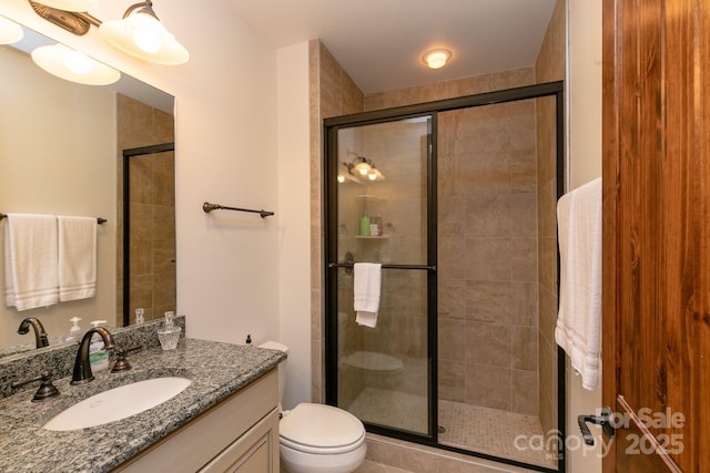 bathroom with walk in shower, vanity, and toilet