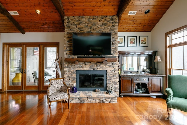 unfurnished living room featuring lofted ceiling with beams, hardwood / wood-style flooring, a fireplace, and wood ceiling