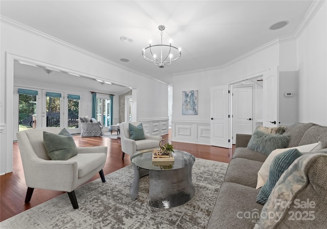 living room featuring dark hardwood / wood-style floors, ornamental molding, and a notable chandelier