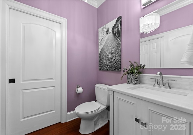 bathroom with hardwood / wood-style floors, vanity, ornamental molding, and toilet