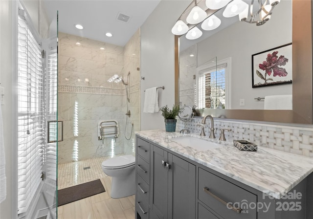 bathroom with decorative backsplash, vanity, toilet, and an enclosed shower