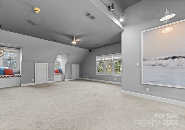 bonus room featuring ceiling fan, a healthy amount of sunlight, lofted ceiling, and light carpet