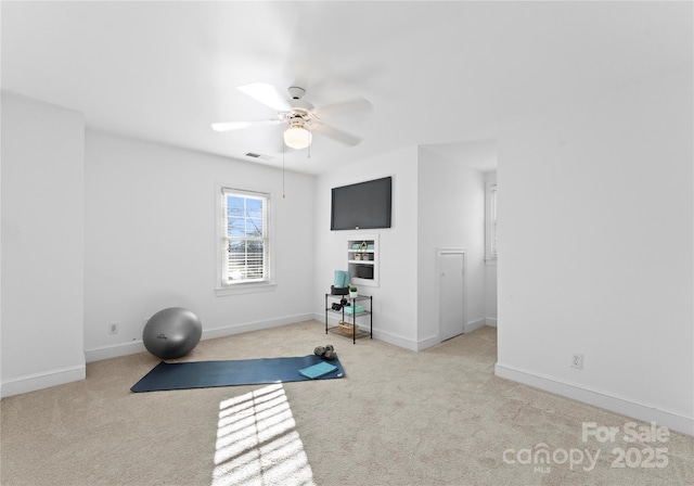 exercise room with light carpet and ceiling fan