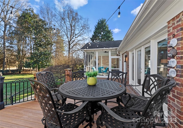 wooden terrace with a yard and a sunroom