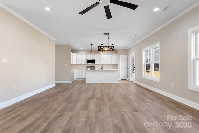 unfurnished living room featuring ceiling fan, light wood-type flooring, and crown molding