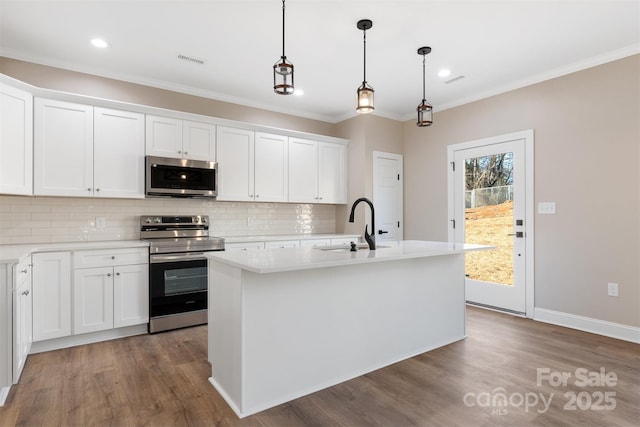 kitchen with white cabinets, a center island with sink, sink, and appliances with stainless steel finishes