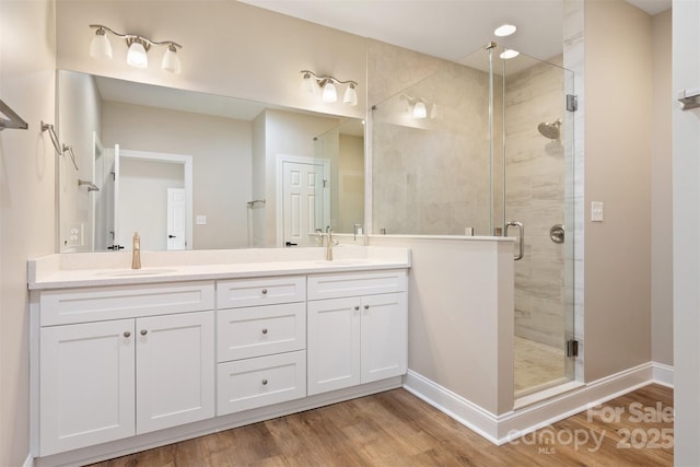 bathroom featuring vanity, hardwood / wood-style flooring, and a shower with shower door