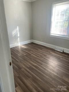 unfurnished room with plenty of natural light and dark wood-type flooring