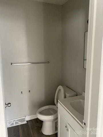 bathroom featuring vanity, hardwood / wood-style flooring, and toilet