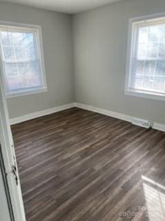 unfurnished room featuring dark hardwood / wood-style floors and plenty of natural light