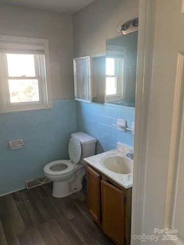 bathroom featuring plenty of natural light, vanity, hardwood / wood-style floors, and toilet