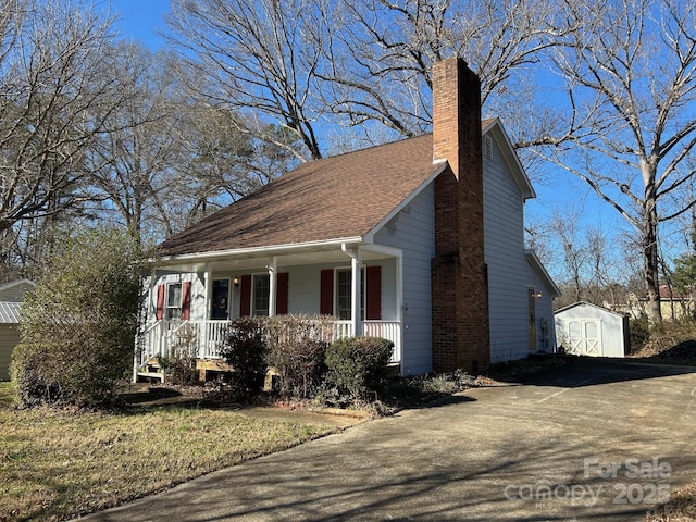 view of front of home featuring a porch and a storage unit