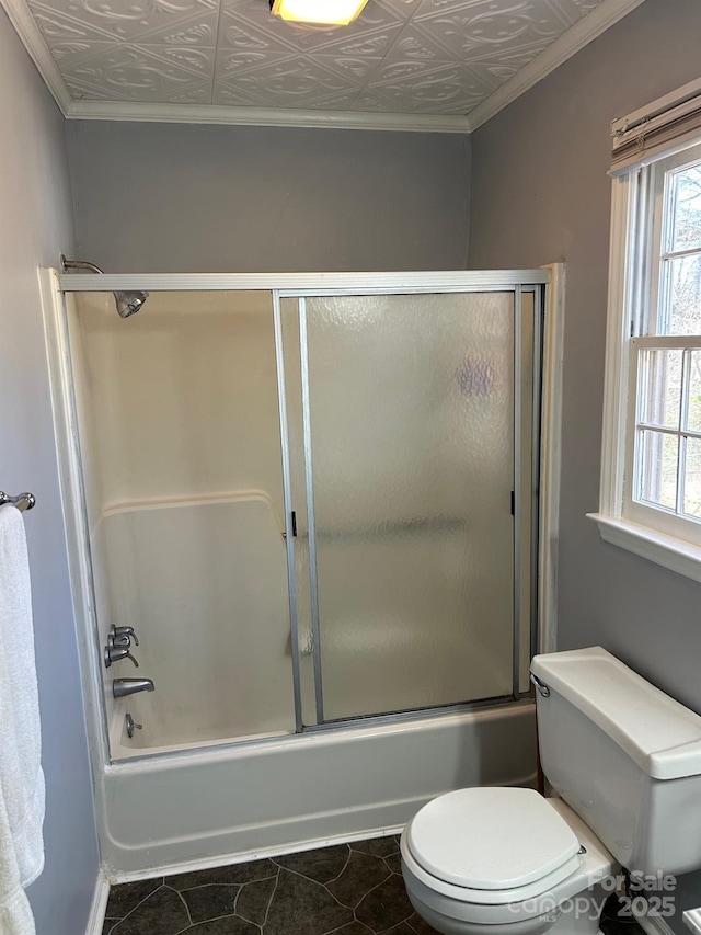 bathroom with shower / bath combination with glass door, tile patterned floors, and toilet