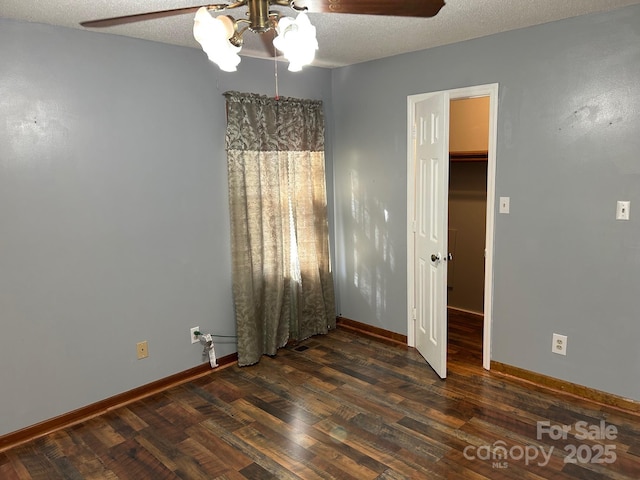 unfurnished room featuring a textured ceiling, dark hardwood / wood-style floors, and ceiling fan