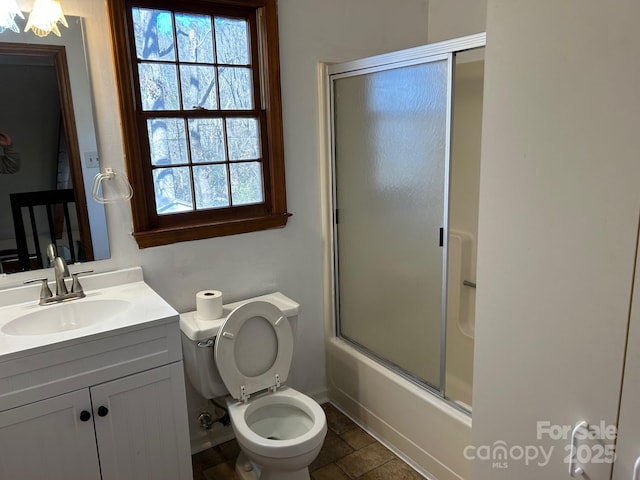 full bathroom with tile patterned flooring, vanity, toilet, and bath / shower combo with glass door