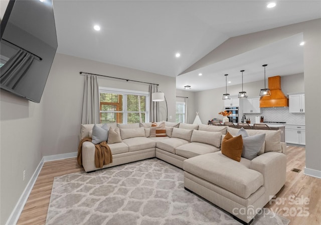 living room with light hardwood / wood-style flooring and lofted ceiling