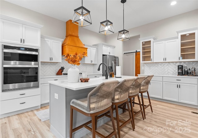 kitchen with pendant lighting, an island with sink, a breakfast bar area, and stainless steel appliances