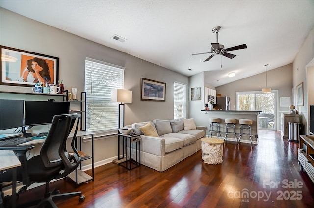 home office featuring ceiling fan, a healthy amount of sunlight, dark wood-type flooring, and vaulted ceiling