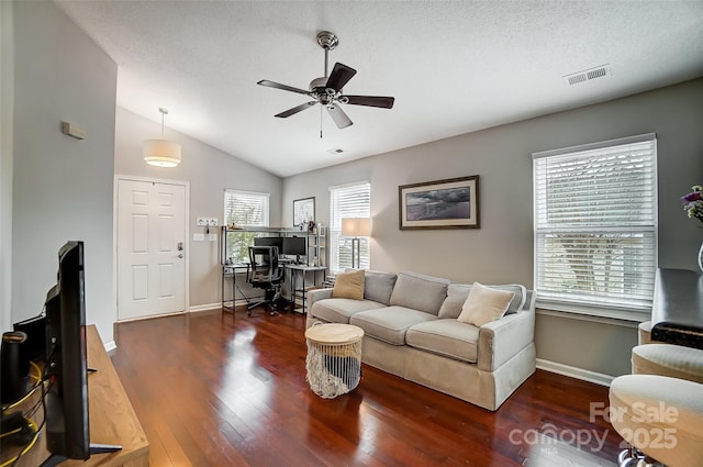 living room with a textured ceiling, vaulted ceiling, ceiling fan, and dark wood-type flooring