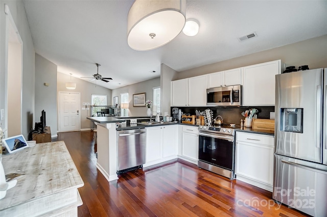 kitchen featuring white cabinetry, ceiling fan, kitchen peninsula, lofted ceiling, and appliances with stainless steel finishes