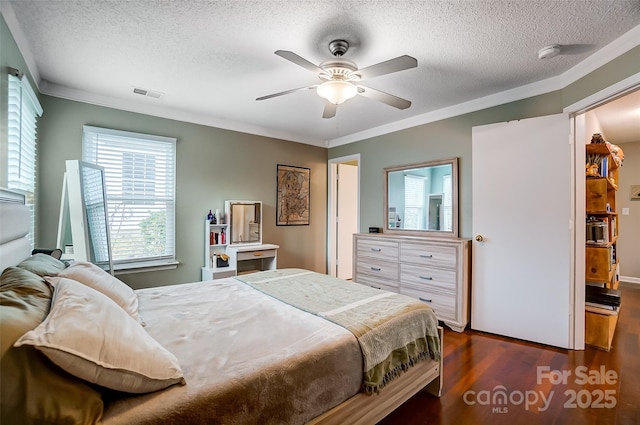 bedroom with a textured ceiling, ceiling fan, dark hardwood / wood-style floors, and crown molding