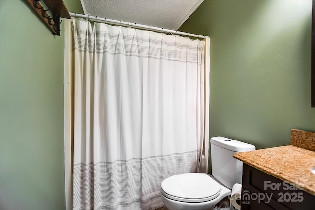 bathroom with vanity, curtained shower, toilet, and a textured ceiling