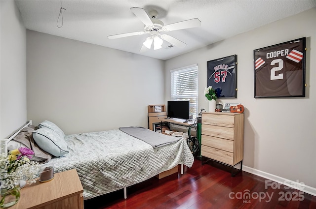 bedroom featuring ceiling fan, dark hardwood / wood-style flooring, and a textured ceiling