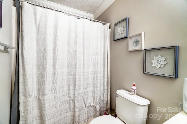 bathroom with toilet, crown molding, and a textured ceiling