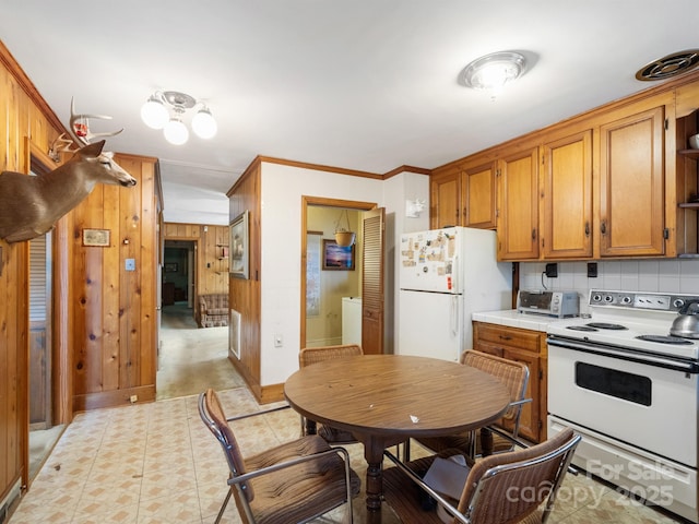 kitchen featuring decorative backsplash, white appliances, and ornamental molding