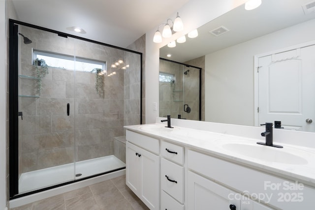 bathroom with tile patterned flooring, vanity, and a shower with shower door