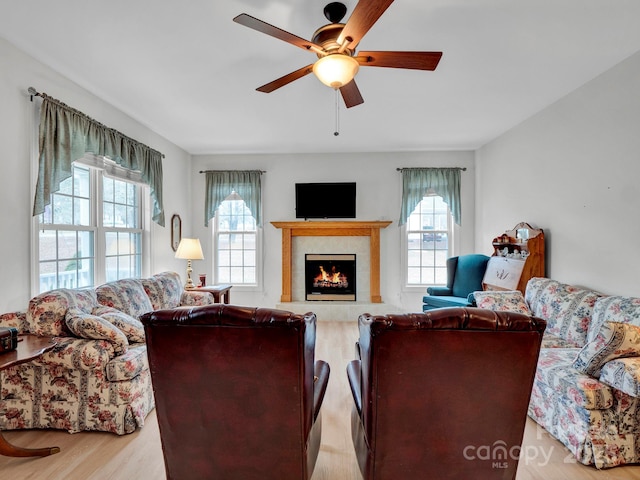 living room featuring a wealth of natural light, light hardwood / wood-style flooring, and a high end fireplace