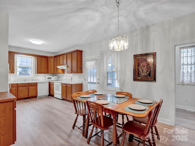 dining room featuring light hardwood / wood-style floors, a notable chandelier, and sink