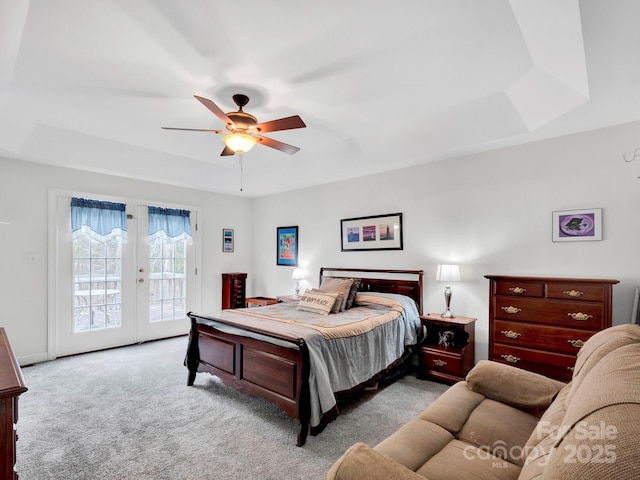 bedroom with access to outside, french doors, a raised ceiling, ceiling fan, and light colored carpet