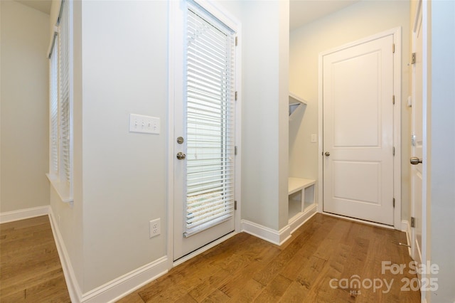 doorway with light wood-type flooring and baseboards