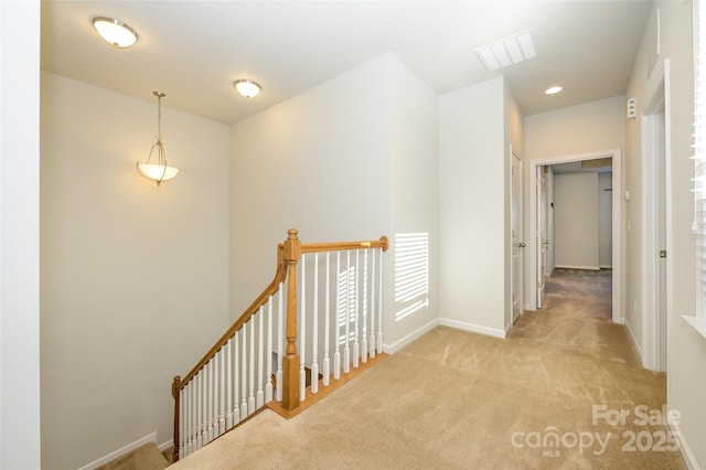 corridor with carpet floors, recessed lighting, visible vents, an upstairs landing, and baseboards