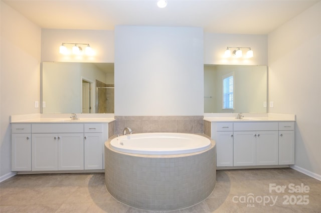 bathroom featuring a sink, two vanities, a shower stall, and a garden tub