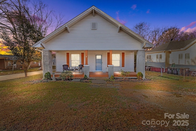 view of front of property with a lawn and a porch