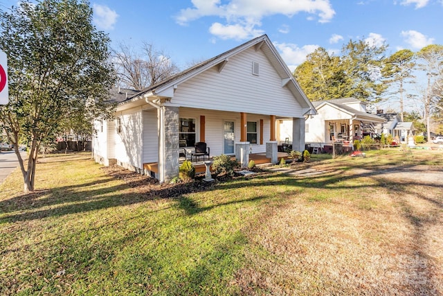 view of front of home featuring covered porch and a front lawn