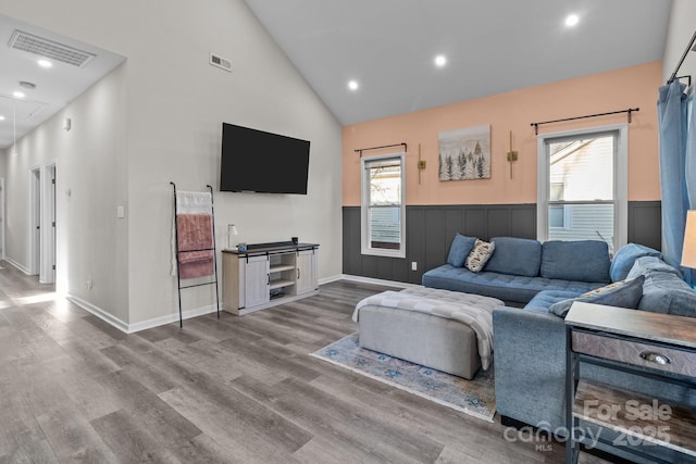 living room with hardwood / wood-style flooring and high vaulted ceiling