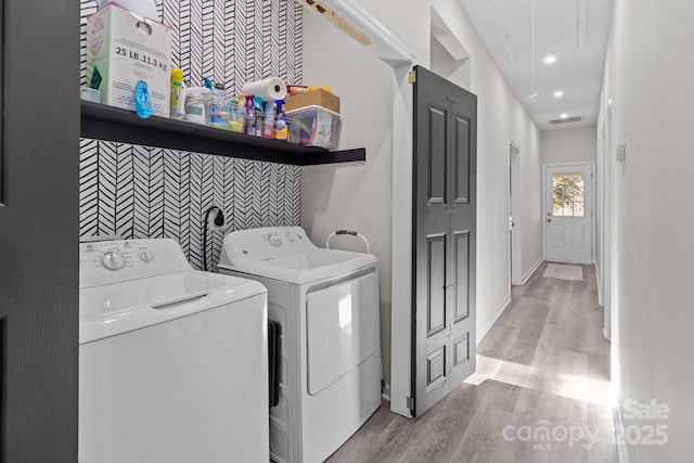 laundry room featuring light hardwood / wood-style floors and washing machine and clothes dryer