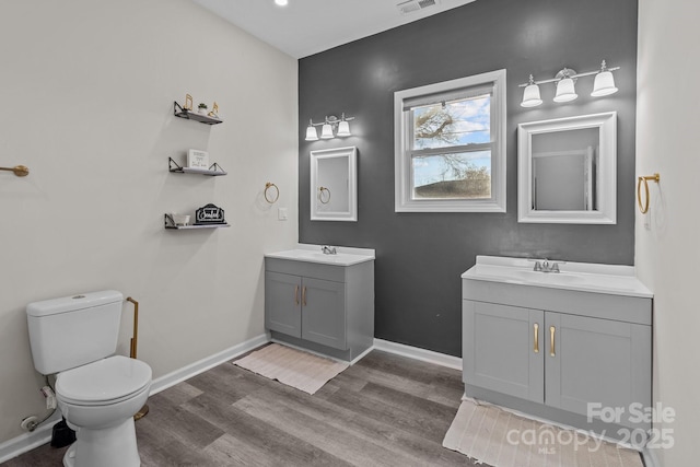 bathroom featuring hardwood / wood-style flooring, vanity, and toilet