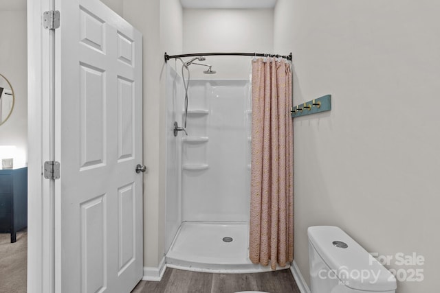 bathroom with a shower with curtain, toilet, and wood-type flooring