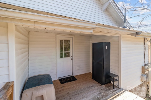 view of exterior entry featuring a wooden deck